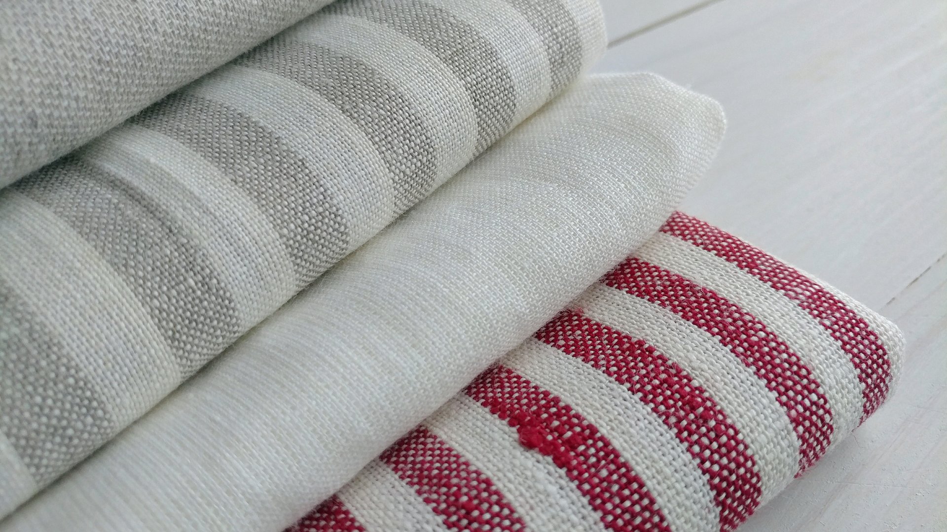 Stacked handwoven cotton fabric highlighting texture, structure, and natural wear.